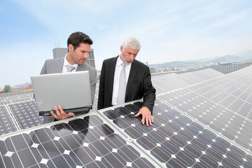 Business people standing by solar panels