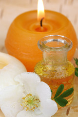Fototapeta na wymiar Aromatherapie mit Rosenöl, Duftkerzen und Blüten