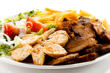 Grilled meat with French fries and vegetables