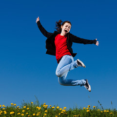 Girl jumping, running against blue sky