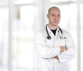 Smiling confident doctor standing with hands crossed