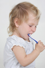 cute child cleaning teeth over white