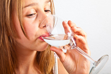 portrait of cute young teenage girl drinking out of a glass