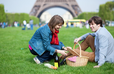 Young couple having a picnic near the Eiffel tower