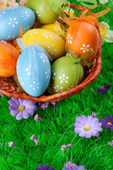 color easter eggs in basket on the green grass