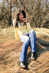Naklejka na ściany i meble girl sitting on the hay in blue jeans