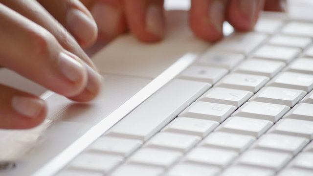 closeup of hands working on laptop touchpad