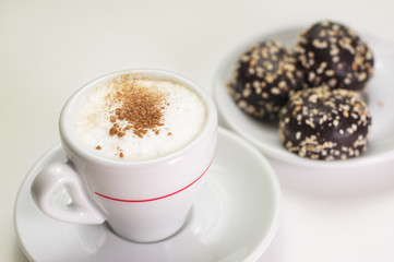 Cup of cappuccino coffee with chocolate candy