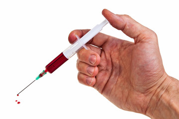 Syringe with red liquid hold by male hand over white background.