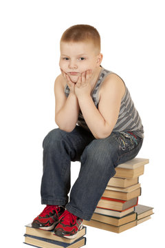 little boy sitting on his head in his hands books