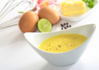 Hollandaise sauce with black pepper and the ingredients