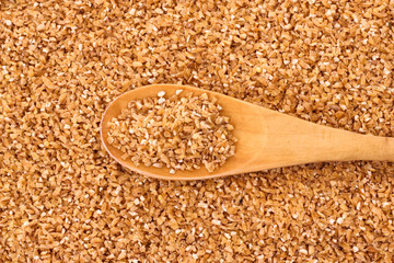 Fine-ground barley with spoon as texture