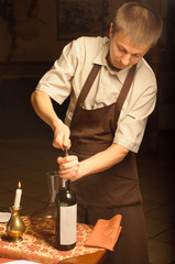 A sommelier opening wine bottle for blind winetasting