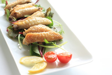 Asian cuisine, spicy chicken wings on green salad