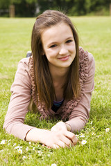 junges M&auml;dchen liegt im Gras