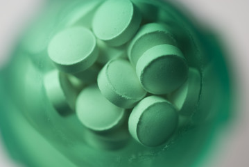 Macro view of pills shot in a green medicine bottle
