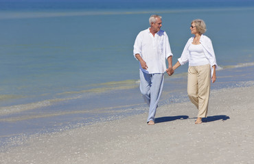 Happy Senior Couple Walking Holding Hands on Beach