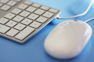 stylish white keyboard and mouse on blue