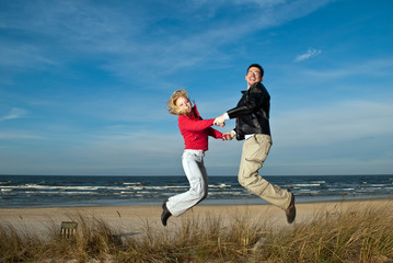 Paar springt in den Dünen