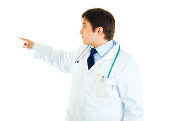Medical doctor pointing finger in corner  at copy space