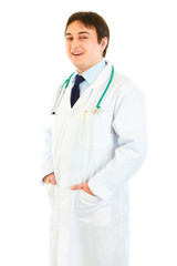Fototapeta premium Smiling medical doctor with hands in pockets isolated on white.