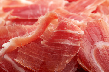 Spanish Serrano Ham Jamon sliced closeup background