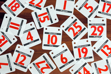 Calendar dates spread out on a wooden desk.