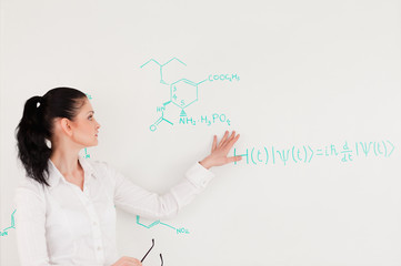 Scientist explaining a formula written on a white board