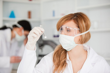 Blond-haired scientist observing a test tube