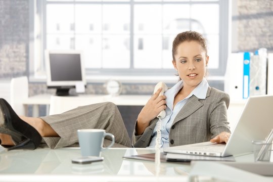 Attractive businesswoman using laptop in office