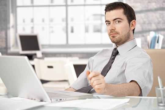 Young man sitting at desk using laptop