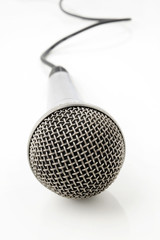 Silver microphone with black wire on white