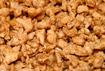 Slices of chicken fried in vegetable oil.