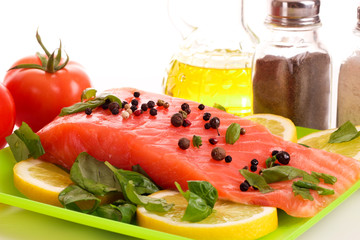 Red fish with pepper and green leaves isolated on white
