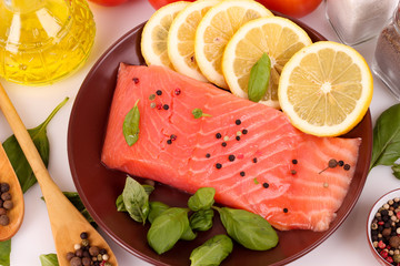 Red fish on the plate with pepper and green leaves