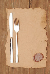 knife and fork on old paper. space for the text