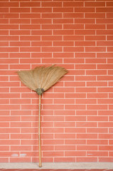 Broom on brick wall
