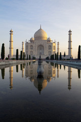 Fototapeta na wymiar Taj Mahal at sunrise reflecting in the pond.