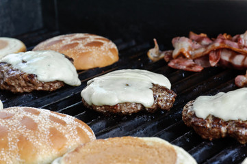 Hamburger buns and bacon on the grill