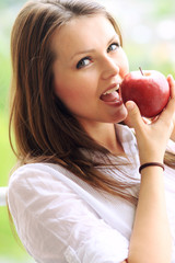 Beautiful smiling woman holding apple