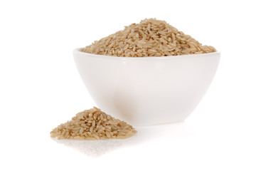 Brown rice in a bowl isolated on a white background.