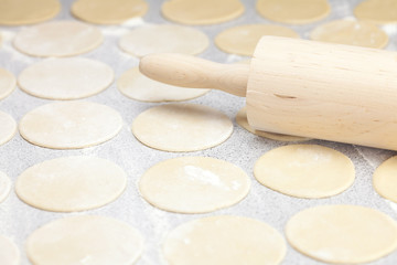Fototapeta na wymiar round shape of the dough and rolling pin with flour on the table