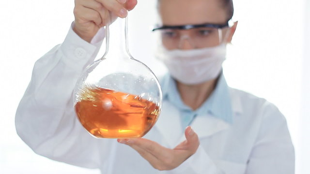 Female scientist mixing chemicals in volumetric flask