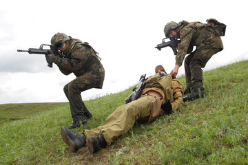 Military evacuation from battlefield. Soldiers evacuating wounded warrior from battlefield