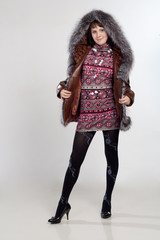 youth woman staning in coat with fur neck isolated