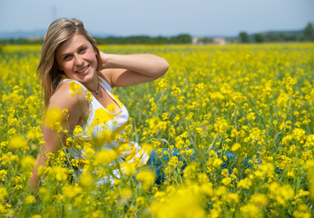 Naklejka na ściany i meble portrait d'une femme souriante dans un champs de colza
