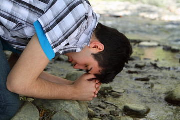 Man Praying by Creek