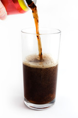 Cola drink pouring into a glass from the can