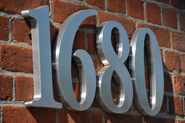 red bricks of a warehouse with silver metallic numbers