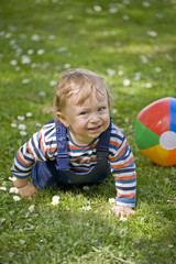 Ein Kind mit Ball auf einer Wiese